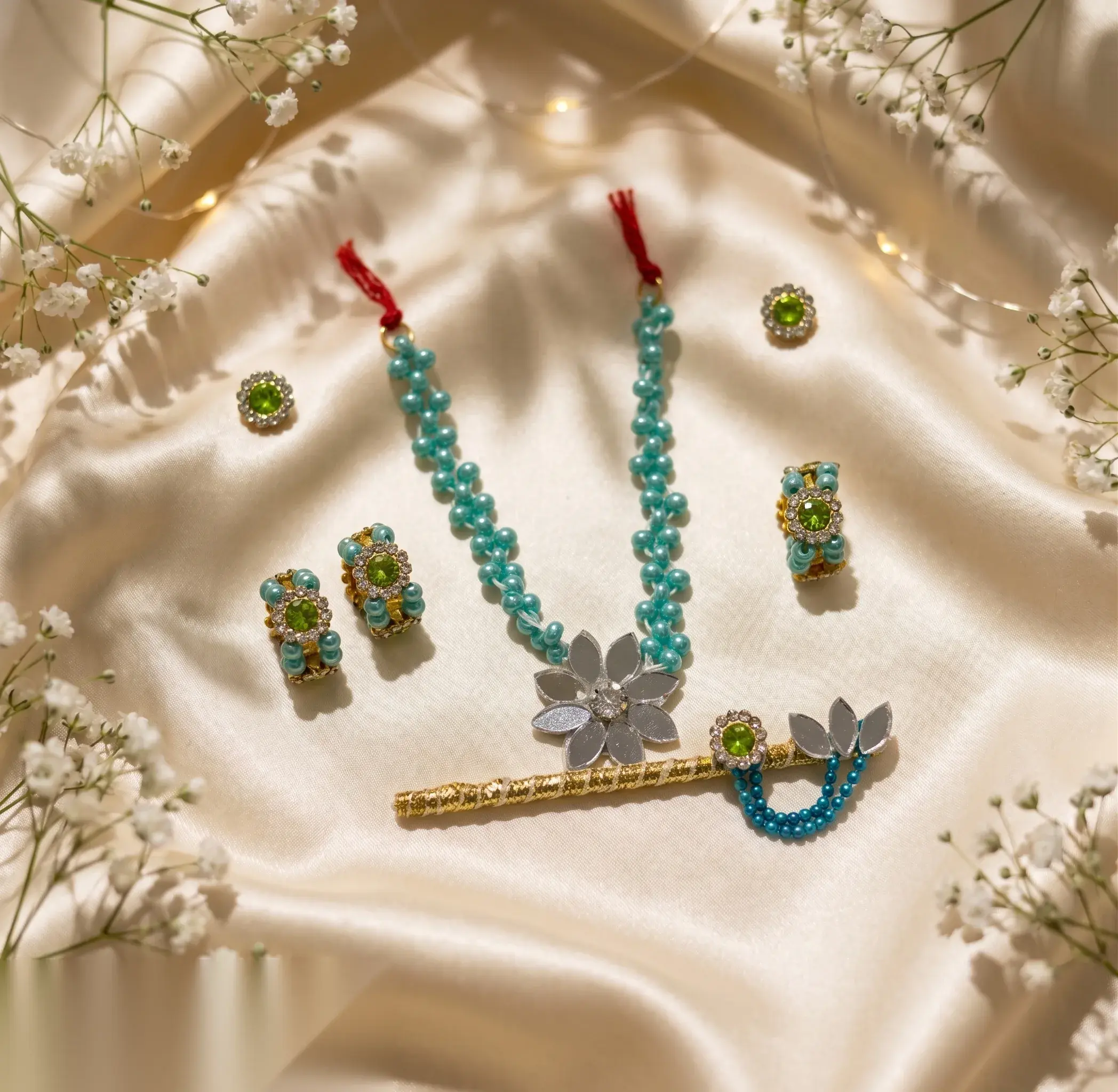 Seven-piece green and turquoise beaded jewellery set with silver flower pendant necklace on display card.