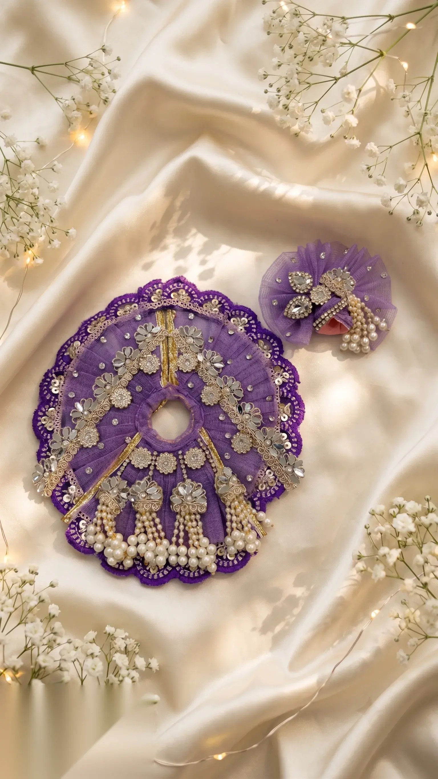 Purple velvet-edged mukut with mirror-work flowers and hanging pearl tassels, beside a net-and-crystal mukut pin.